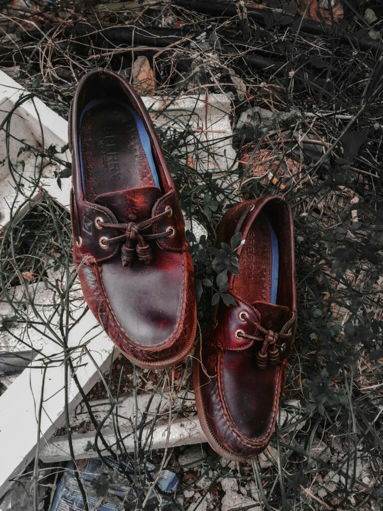 Pair of Brown Sperry Leather Boat Shoes on White Wooden Panel